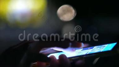夜间妇女通过智能手机显示触摸屏